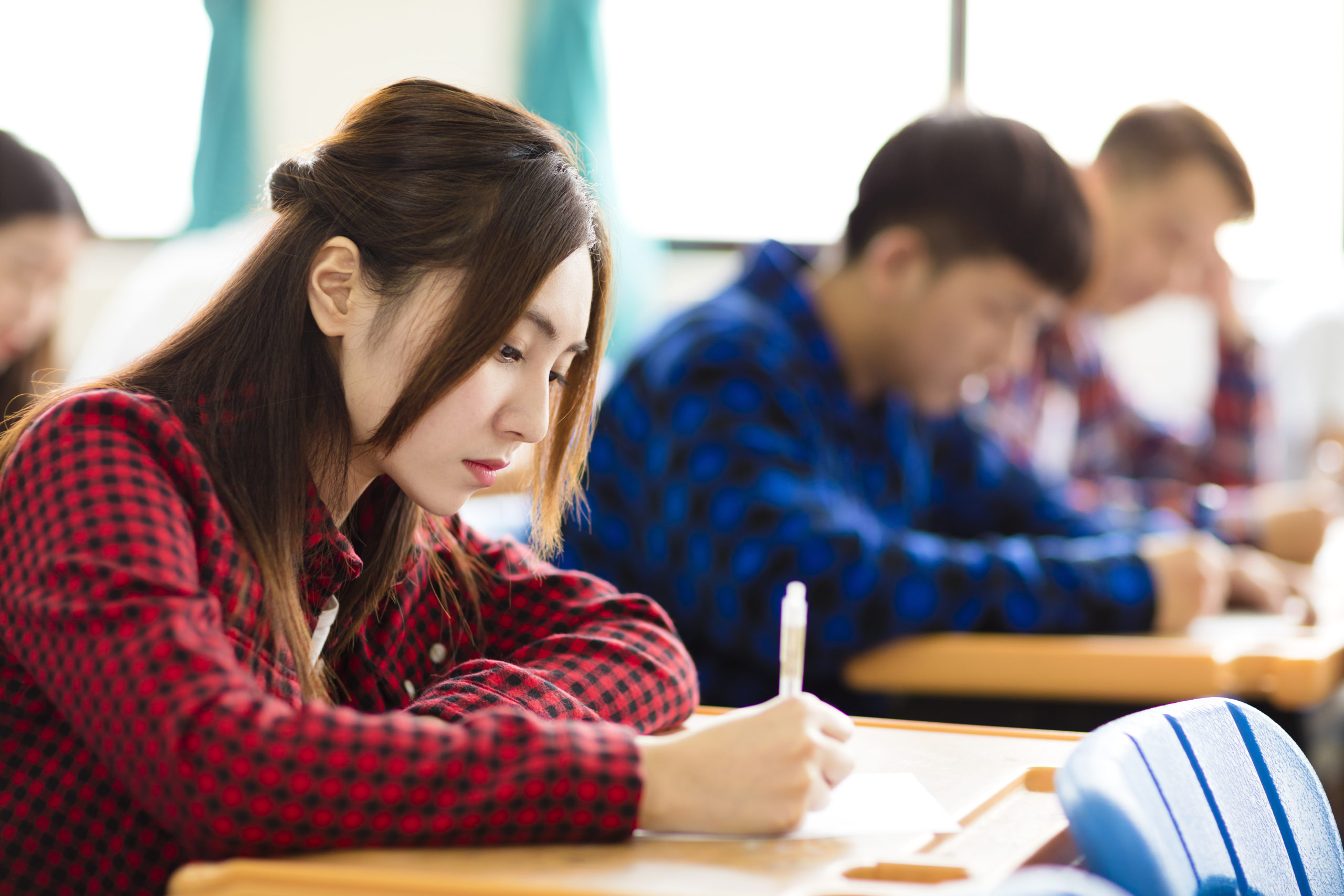 female college student sitting and exam in the classroom